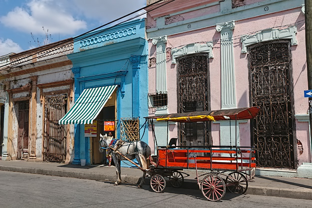 Horse-drawn carriage on the streets of Santa Clara. Travel to Cuba before scenes like this begin to disappear.