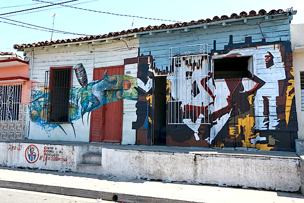 Murals on the houses in neighborhood surrounding Trazos Libres community art project in Cienfuegos, Cuba