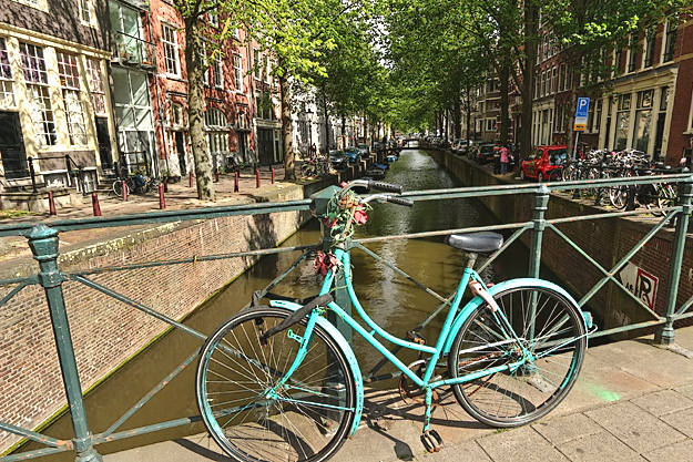 No canal view in Amsterdam is complete without an obligatory bicycle resting against the bridge railing