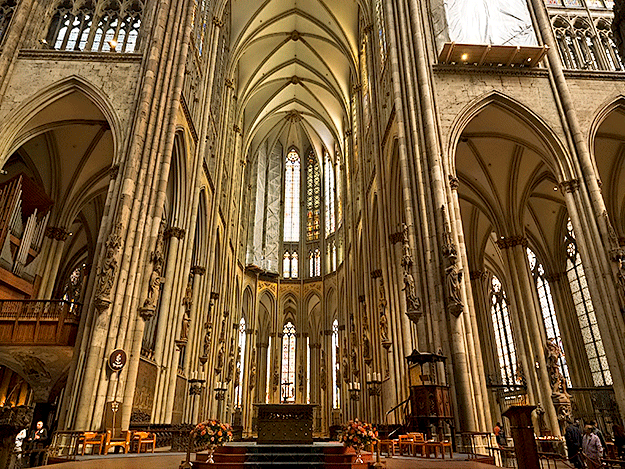The nave of Cologne Cathedral, looking east. Note the wooden pulpit on the right and the north transept organ with gallery on the left