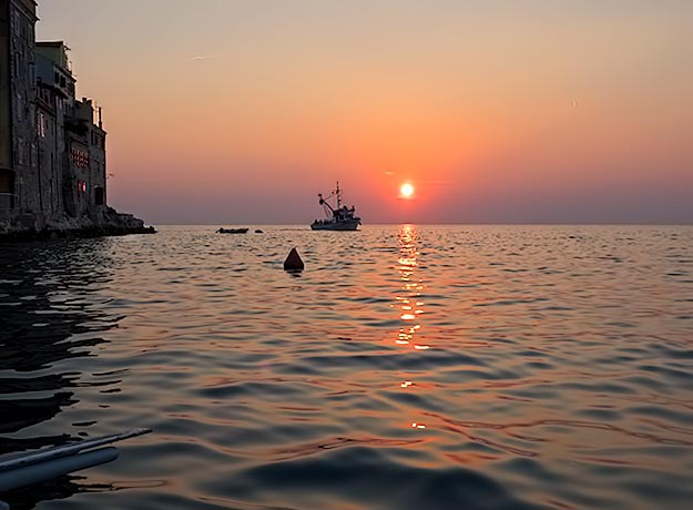 As my batana heads back to the harbor, I enjoy this view of a fishing trawler, the Adriatic, and the setting sun