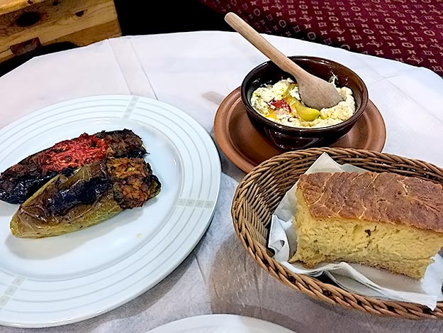 My traditional Albanian meal: peppers stuffed with rice and garlic, roasted eggplant stuffed with onions and tomatoes, soft baked sheep cheese with peppers, and homemade bread