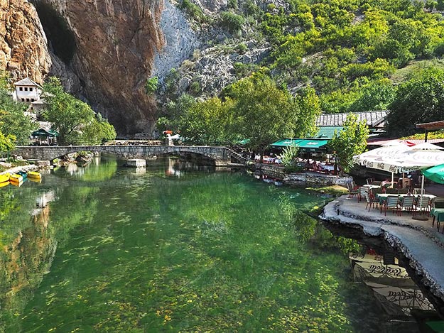 Source of the Buna River flows from a cave in the base of the limestone cliffs near Blagaj, Bosnia-Herzegovina. Impressed by the beauty of the site, in the 16th century an Ottoman mufti ordered a Tekke - a Dervish prayer house - built at the foot of the cliffs. It's white washed walls (far left in the background) create a stunning reflection in the emerald green waters of the river.