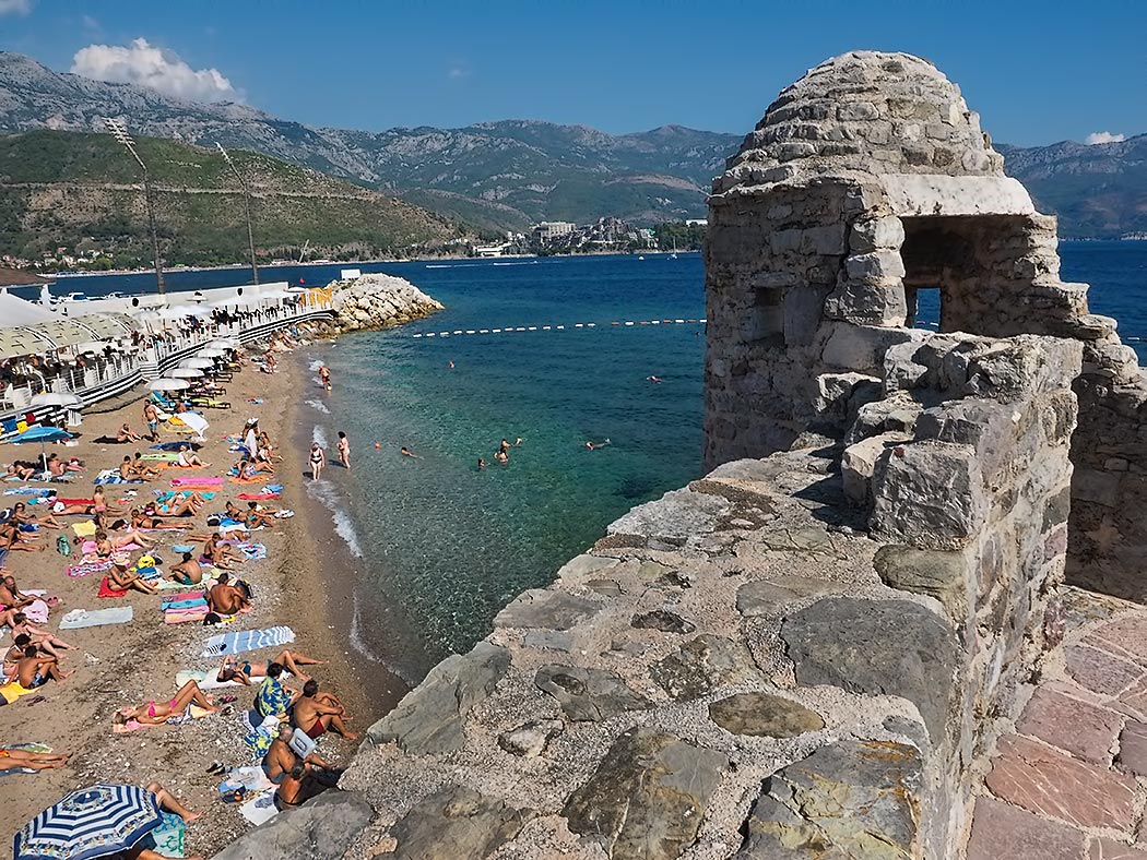Sun worshipers flock to Pizana Beach on the shores of the Adriatic Sea in Budva, Montenegro. Though small, it is one of the more popular beaches, as it is wedged into a protected cove between the walls of the old city and Dukley Beach Club.