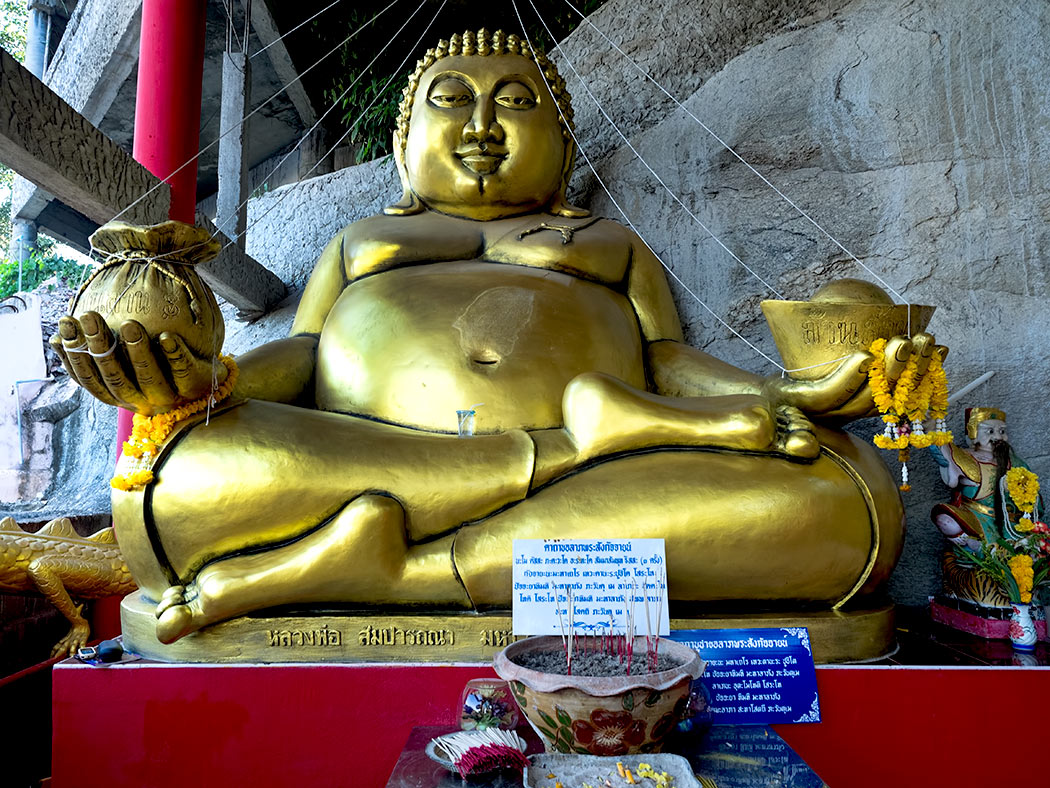 Slipping an offering into the slot in the belly of this giant seated Buddha at Khao Tao temple in Hua Hin, Thailand is said to bring the donor good luck