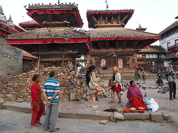 Kathmandu's Durbar Square, where life in Nepal afer the earthquake goes on as usual. This woman still sells corn kernels to fee the ubiquitous pieons that flood the old palace grounds.