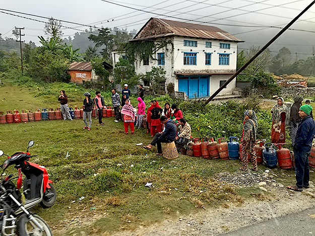 People in a village near Pokhara wait in line to get half a tank of LP gas