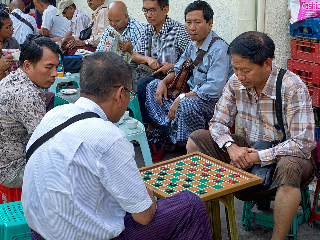 Afternoon break for tea and checkers in Myanmar. Squatting on low plastic stools set out on the streets around the Scott Market in Yangon, they seem oblivious to the cars and motorcycles speeding by with just inches to spare.