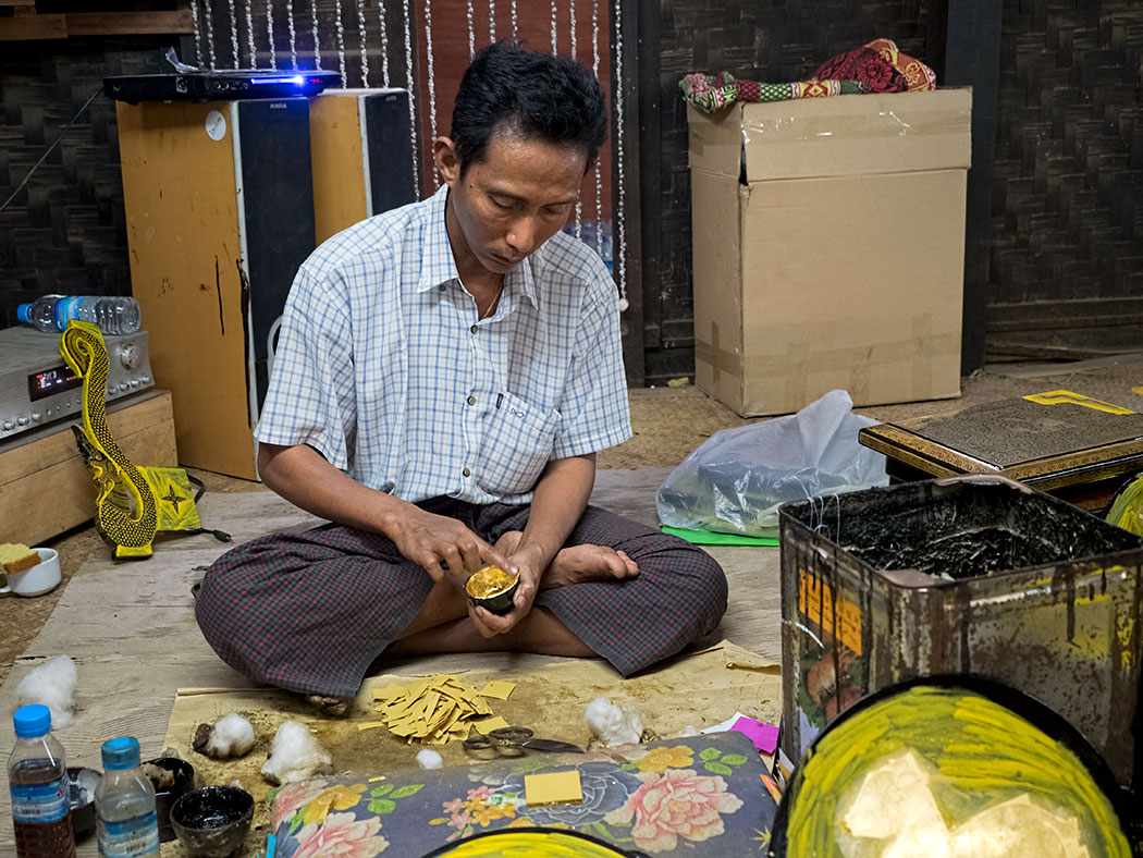 Man applying gold foil on laquerware at a factory in Bagan, Myanmar
