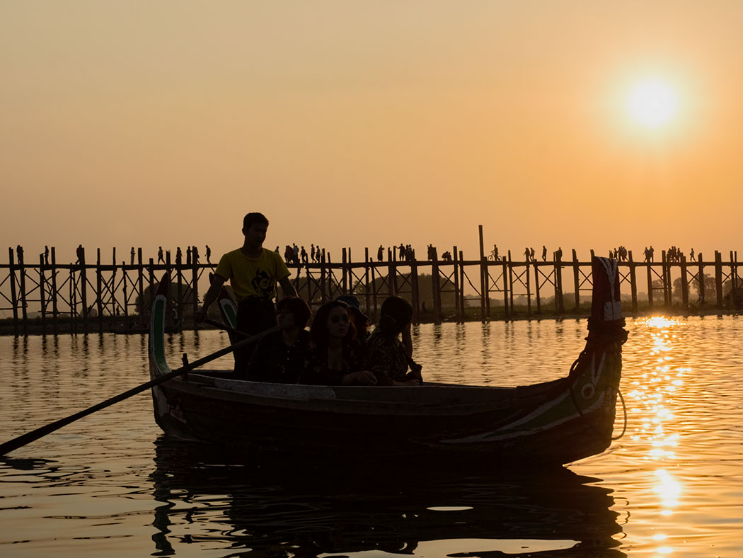In Mandalay, Myanmar, sun sets behind U Bein Bridge, which bisects Taungthaman Lake and is said to be the longest and oldest teak bridge in the world