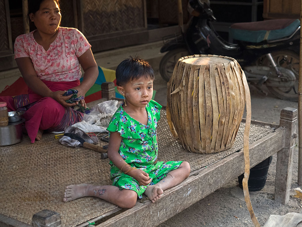 Girl from Ohn Ne Kyaung fishing village near Bagan, Myanmar, sits next to a drum made by her family, which specializes in making percussion instruments from locally available materials