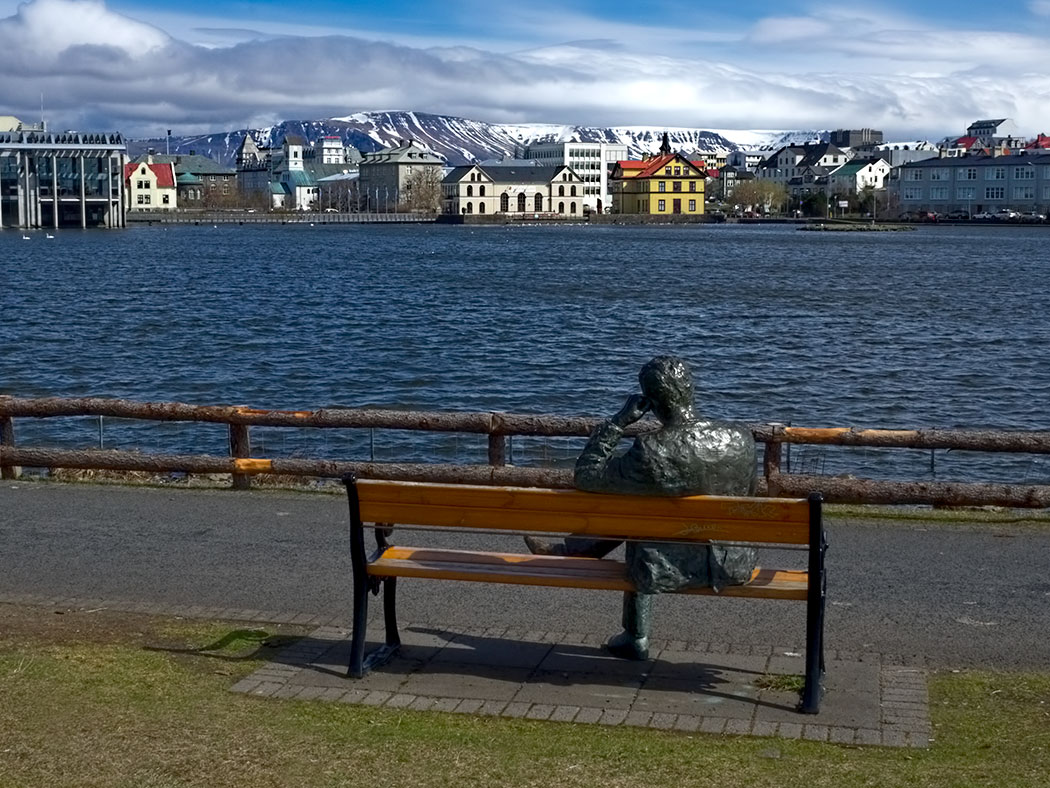 Bronze man enjoys view across the Pond in Reykjavik, Iceland
