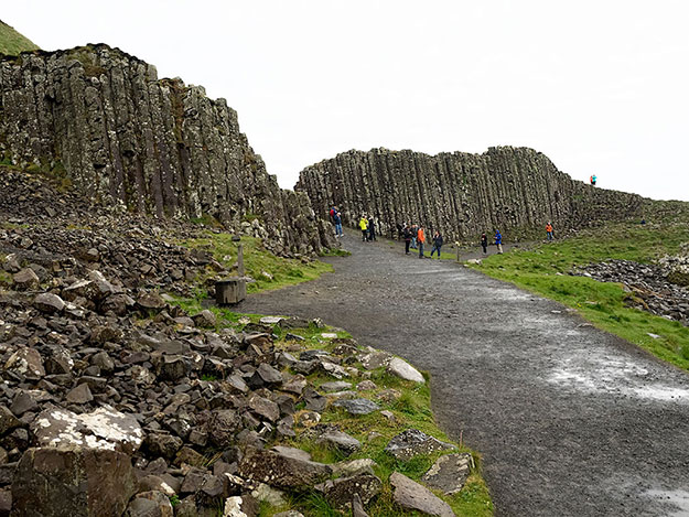 Basalt columns at the Giant's Causeway formed when volcanic eruptions covered previous lava flows, allowing the buried material to cool slowly and make crystallized formations