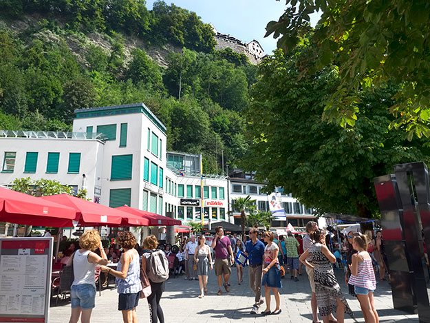 People from all over the world come to enjoy the festivities during National Day in Liechtenstein. Note the castle of the Prince of Liechtenstein on the top of the hill, overlooking the capital of Vaduz.