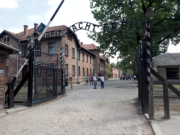 The words "Arbeit Macht Frei" (Work Makes You Free) span the entrance to Auschwitz Concentration Camp