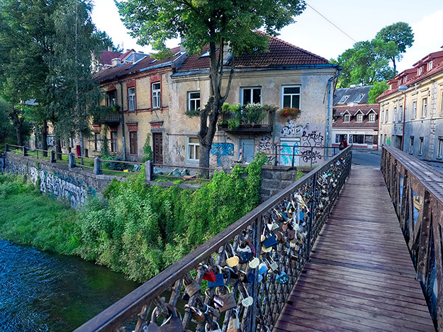 Love-lock laden bridge leads into the Bohemian neighborhood of Uzupis in Vilnius, Lithuania