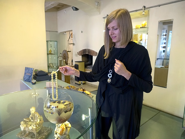 Woman at the Amber Gallery and Museum in Vilnius, Lithuania, demonstrates how to separate real amber from fake by immersing it into a 10% salt water solution.