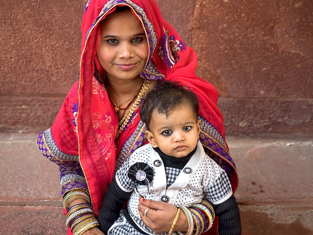 Mother and child take a break from walking under a blistering sun at the Red Fort of Agra in Agra, India