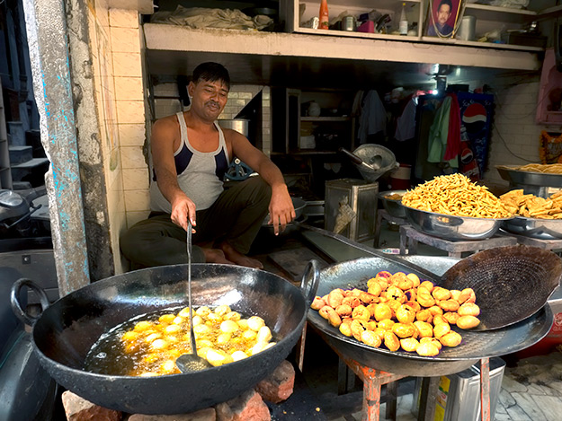 Man in a tiny storefront in Old Delhi makes Indian fry bread