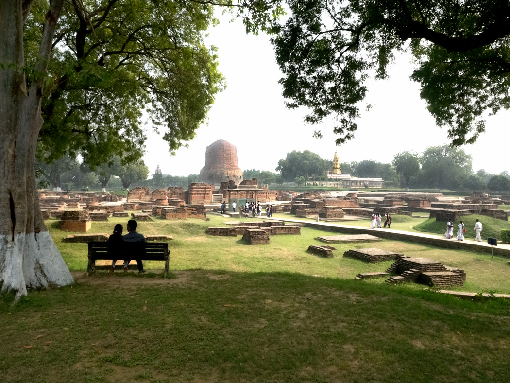 Archeological excavations of ancient Buddhist monasteries in Sarnath, India. Gautama Buddha first taught the Dharma here. The three structures in the distance, from left to right, are the Main Temple, the Dhamekh Stupa, and the Jain Temple