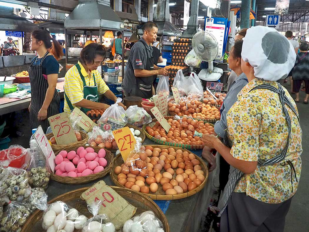 Egg sellers serve customers at the Chiang Mai Gate market each morning. Unlike the U.S., eggs are not refrigerated in Thailand. So do eggs need to be refrigerated?