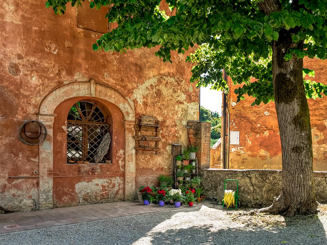 Centuries old palaces at Montestigliano luxury holiday farm in Tuscany, Italy, are drenched in shades of gold and burnt orange under the setting sun