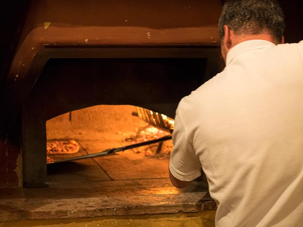 Making pizzas in the old wood-fired oven at Montestigliano holiday farm in Tuscany