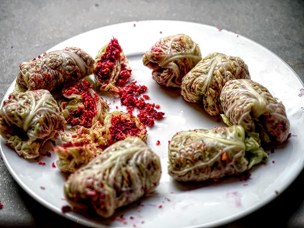 Cabbage rolls, stuffed with shredded beetroot, carrot, and coconut