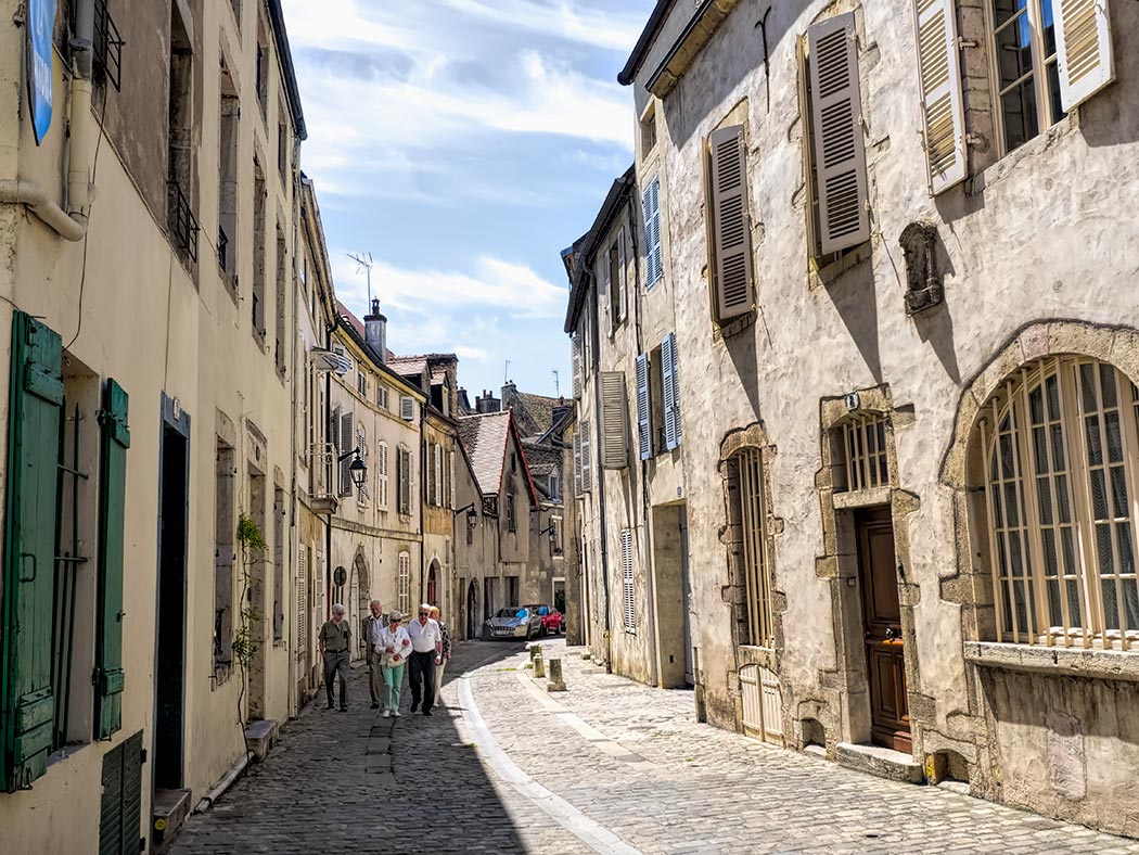 Ancient masonry facades and colorful wooden shutters adorn the medieval houses of Beaune, France