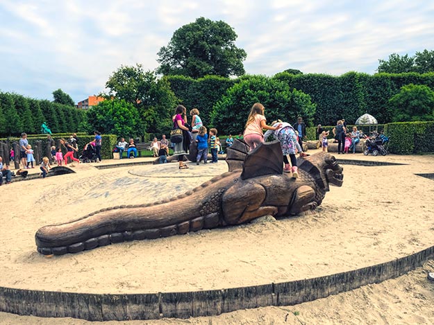 Kids climb on a giant lizard in the playground at King's Garden in Copenhagen, Denmark