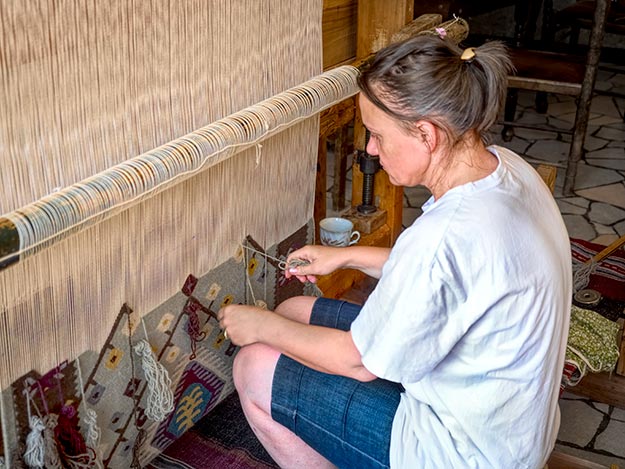 Velika Stoeva, owner of Chushkarcheto Carpet Store in Chiprovisti, Bulgaria, weaves a traditional design on a wooden loom