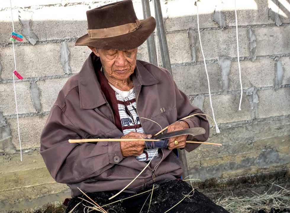 Man carves and shapes bamboo for paper lanterns at the Saa Paper Festival in the village of Ban Ton Pao in northern Thailand