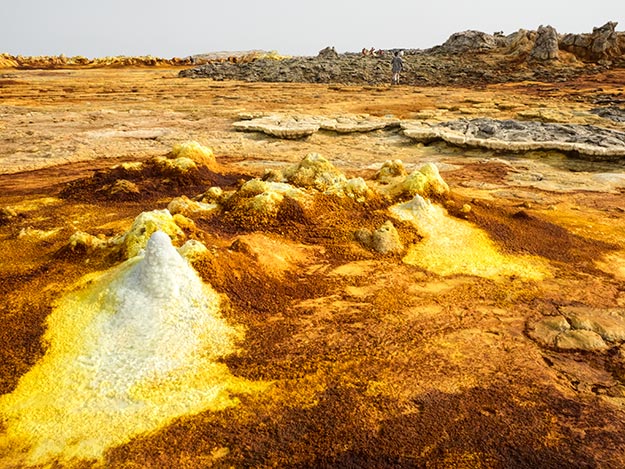 Boiling water shoots up from these mini craters in the Dallol hydro-geothermal sulfur fields, leaving a come of built-up minerals
