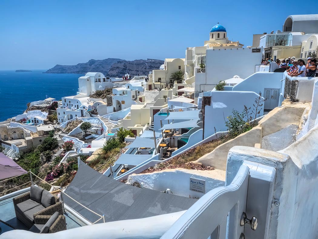 The blue domes and whitewashed houses in the village of Oia exhibit traditional construction methods known as the cave architecture of Santorini