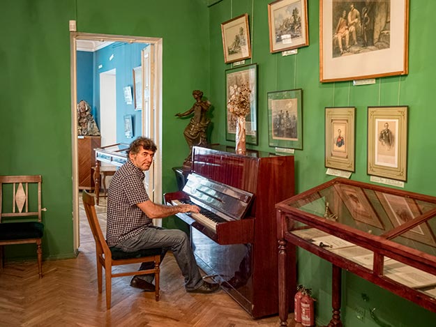 Tour guide Valery Brady serenades me at the Pushkin Museum in Chisinau