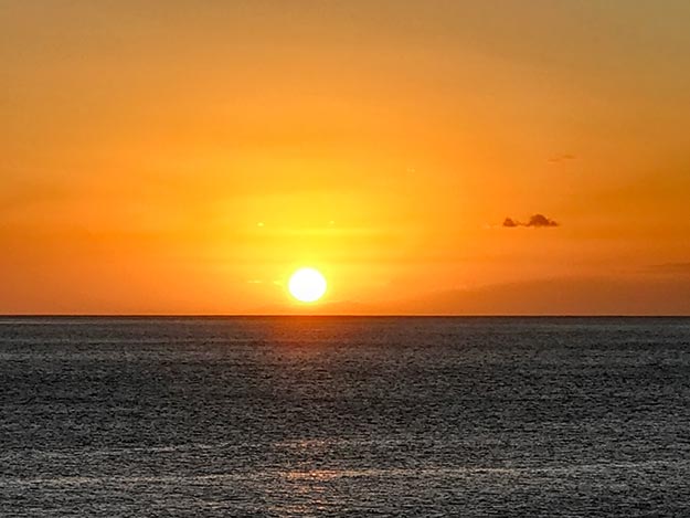 Sun sets as the Aranui 5 cruise ship departs Fatu Hiva island in the Marquesas