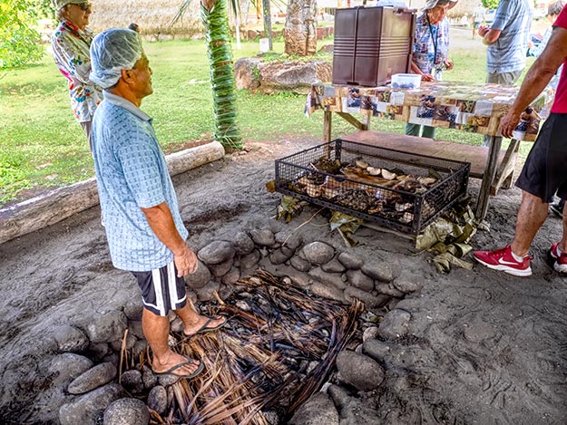 Roasted pig is removed from an underground earth oven on Nuku-Hiva island in the Marquesa Archipelago