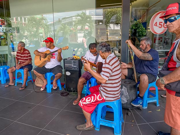 Local musicians belt out traditional Polynesian tunes in front of a drug store in Papeete