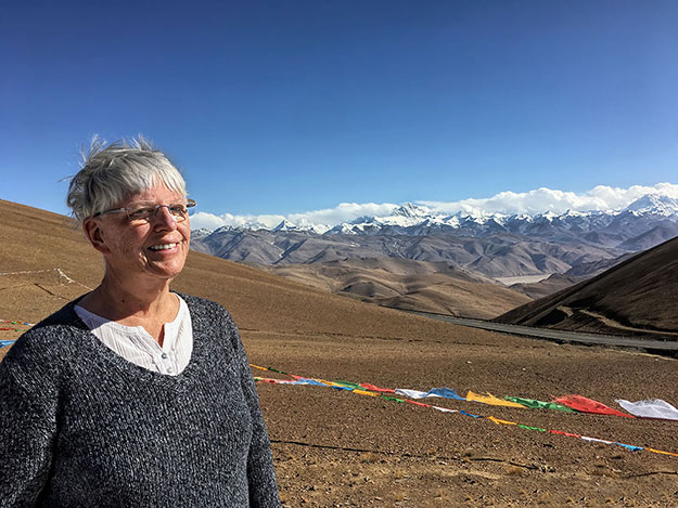 Barbara Weibel at Geu La Pass in Tibet with Mount Everest and the Himalayan Range in the background