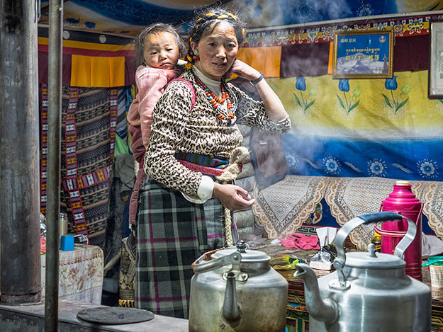 Woman prepares dinner for out group inside The Everest Sunshine Hotel, a yak-skin tent at Everest Base Camp