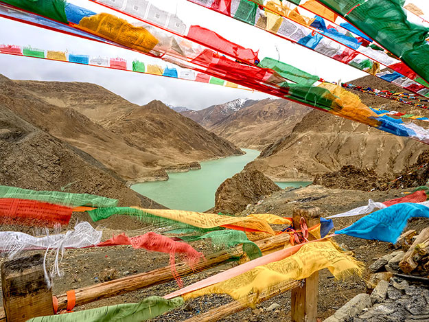 Tibetan prayer flags flap in strong winds at the Manla Reservoir overlook in southern Tibet
