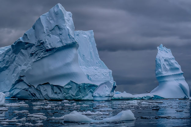 Dramatic skies behind towering icebergs in Cierva Cove