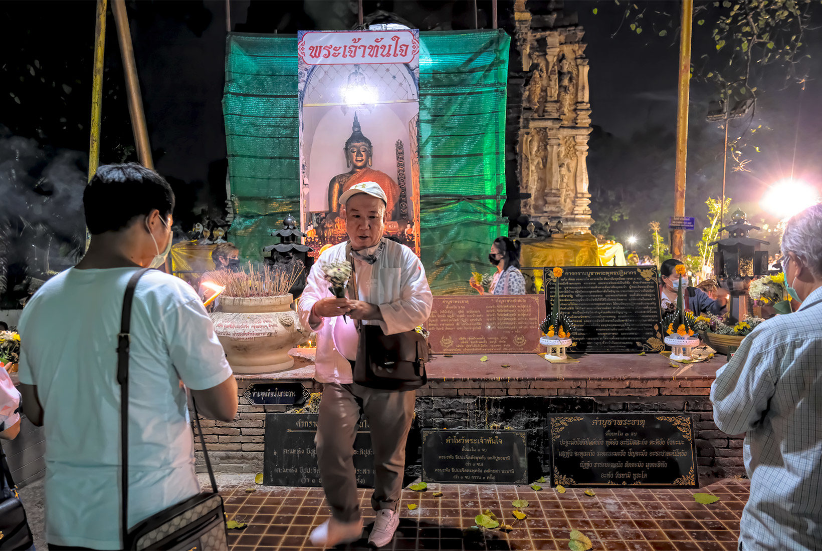 Pop pays respect to Buddha by placing flowers on the altar