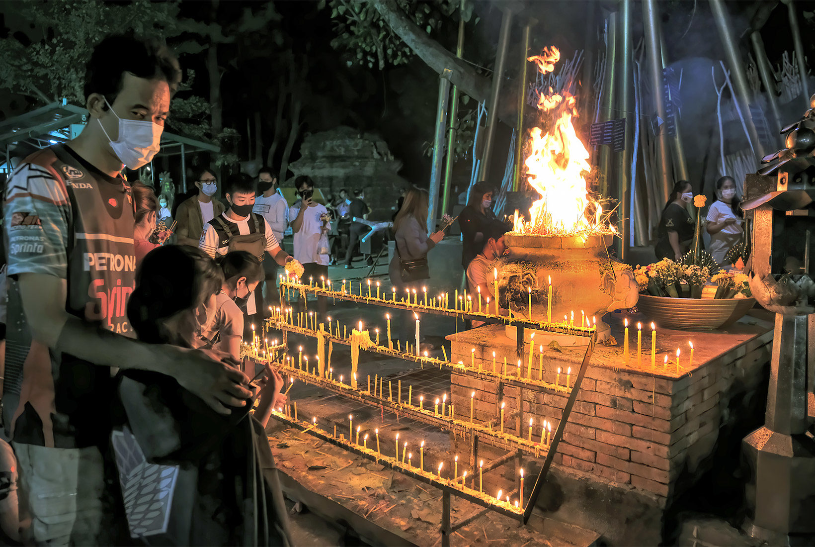 Incense sticks in pots full of sand are set aflame at the end of the Makha Bucha Day ceremonies