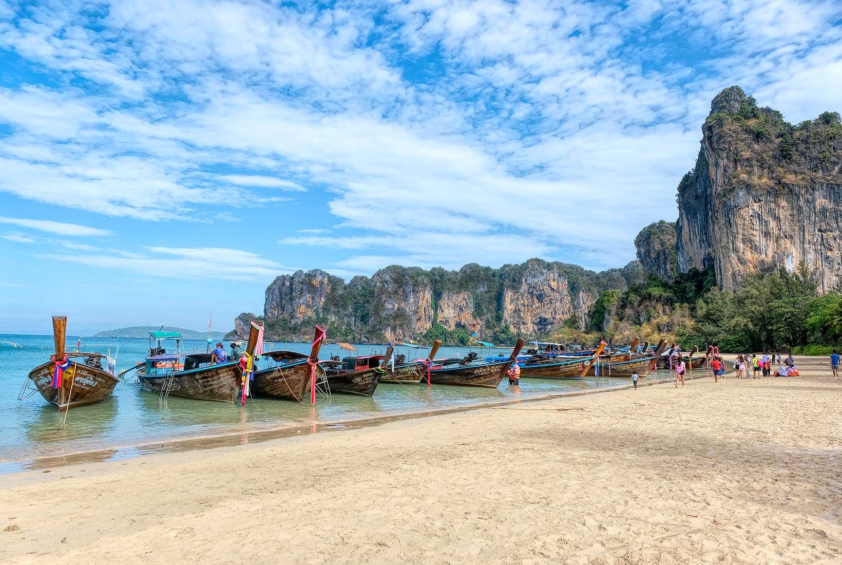 Longtail boats lined up, awaiting passengers on Railay Beach West