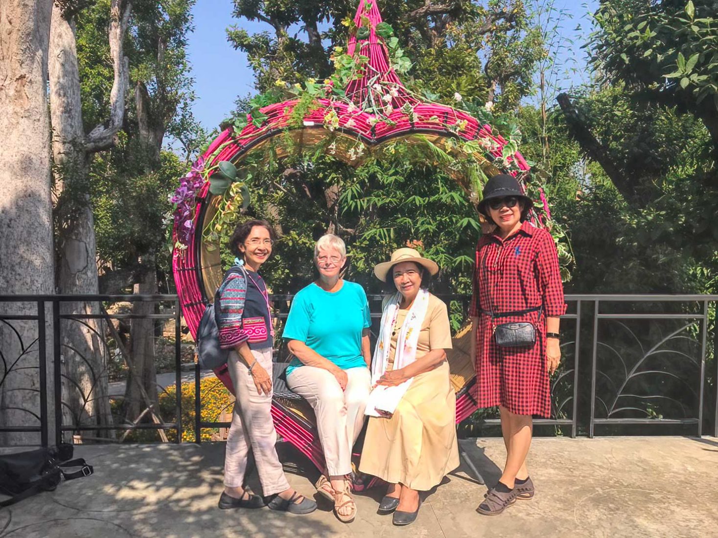 I pose with my Thai friends on a heart-shaped chair on the viewing platform