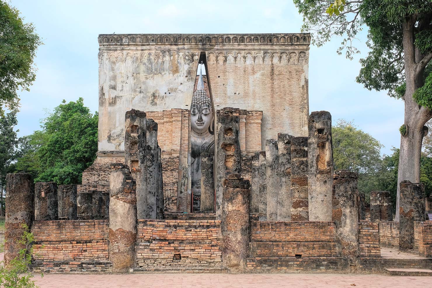 Thailand Sukhothai Historical Park Northern Zone Wat Si Chum with giant Buddha icon peering out door of temple