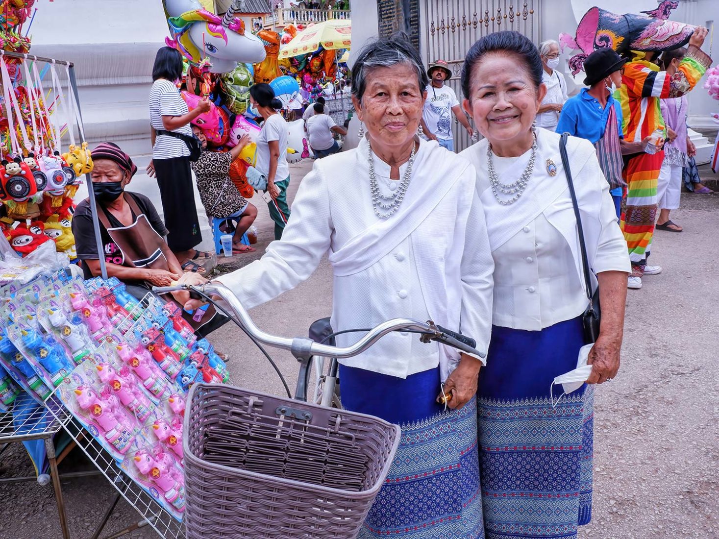 Women in traditional Pha Sin hand woven skirts graciously pose for a photo