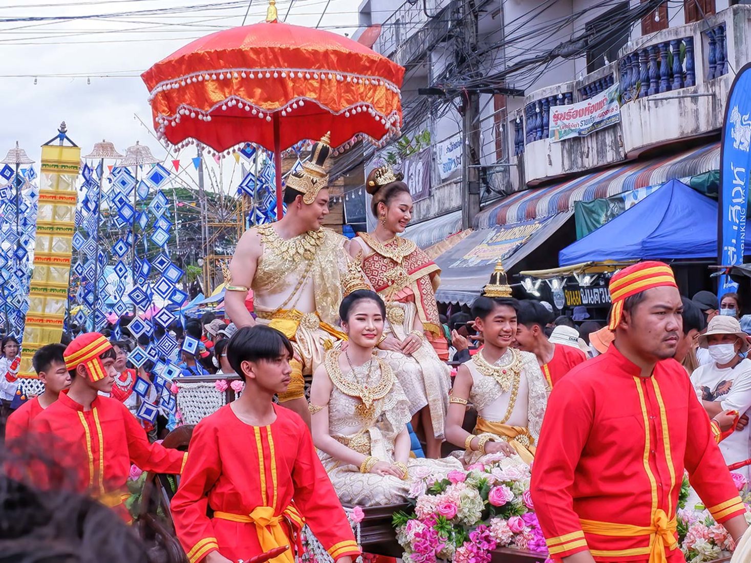 Phi ta Khon Festival king and queen ride atop a float in the parade in Dan Sai