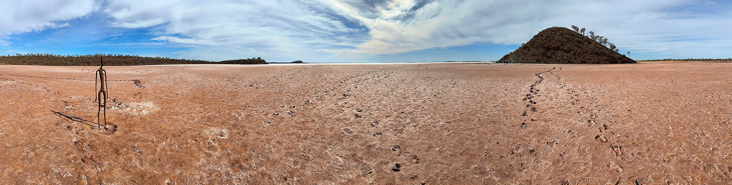 Panoramic View of the dry lake bed and distant salt flats of Lake Ballard in Western Australia, with one of the 51 Antony Gormley sculptures in the foreground